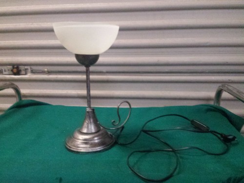 Tafellamp van metaal met witte glazen kap, voorzien van scha