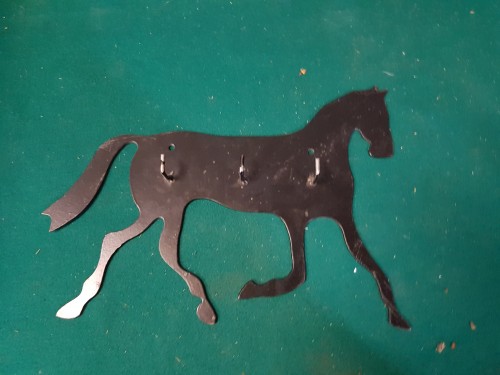 Kapstok van zwart metaal in de vorm van een paard, met drie 