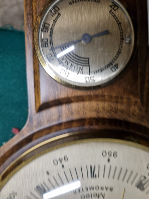 -	Barometer op houten plank