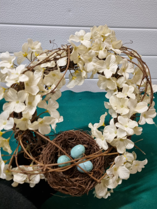 Krans met bloemen en nest eieren