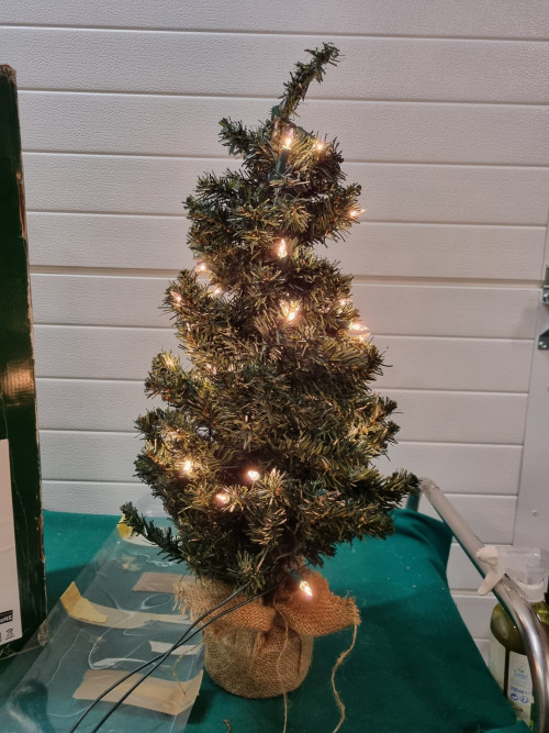 kerstboom met verlichting in jutte zak
